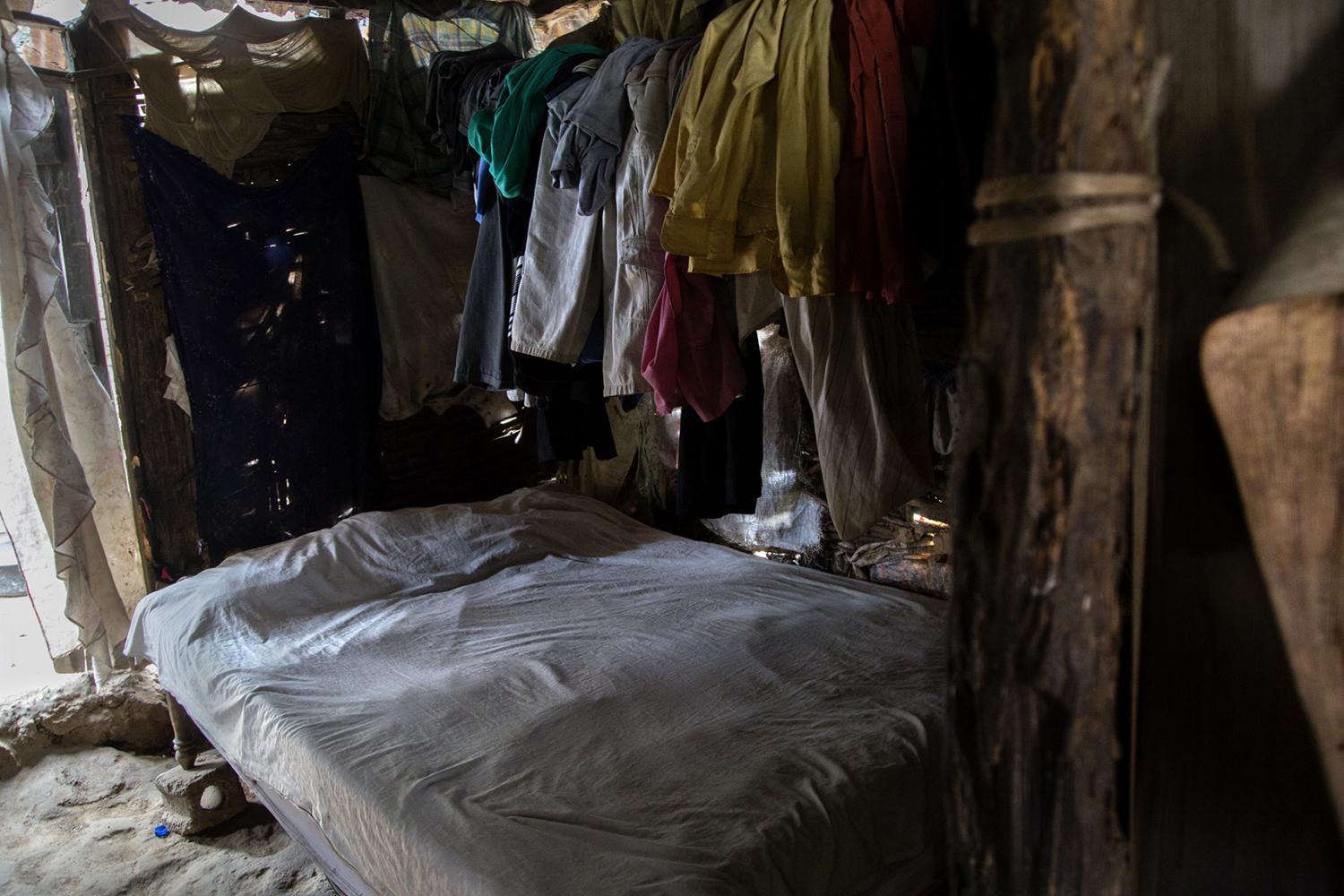 Clothing hangs from the ceiling in this 1 room house to keep it from getting ruined or lost when it rains. With no foundation the water rushes through most homes when the hurricanes hit.  A family of 5 lives in this room in Milot, Haiti.