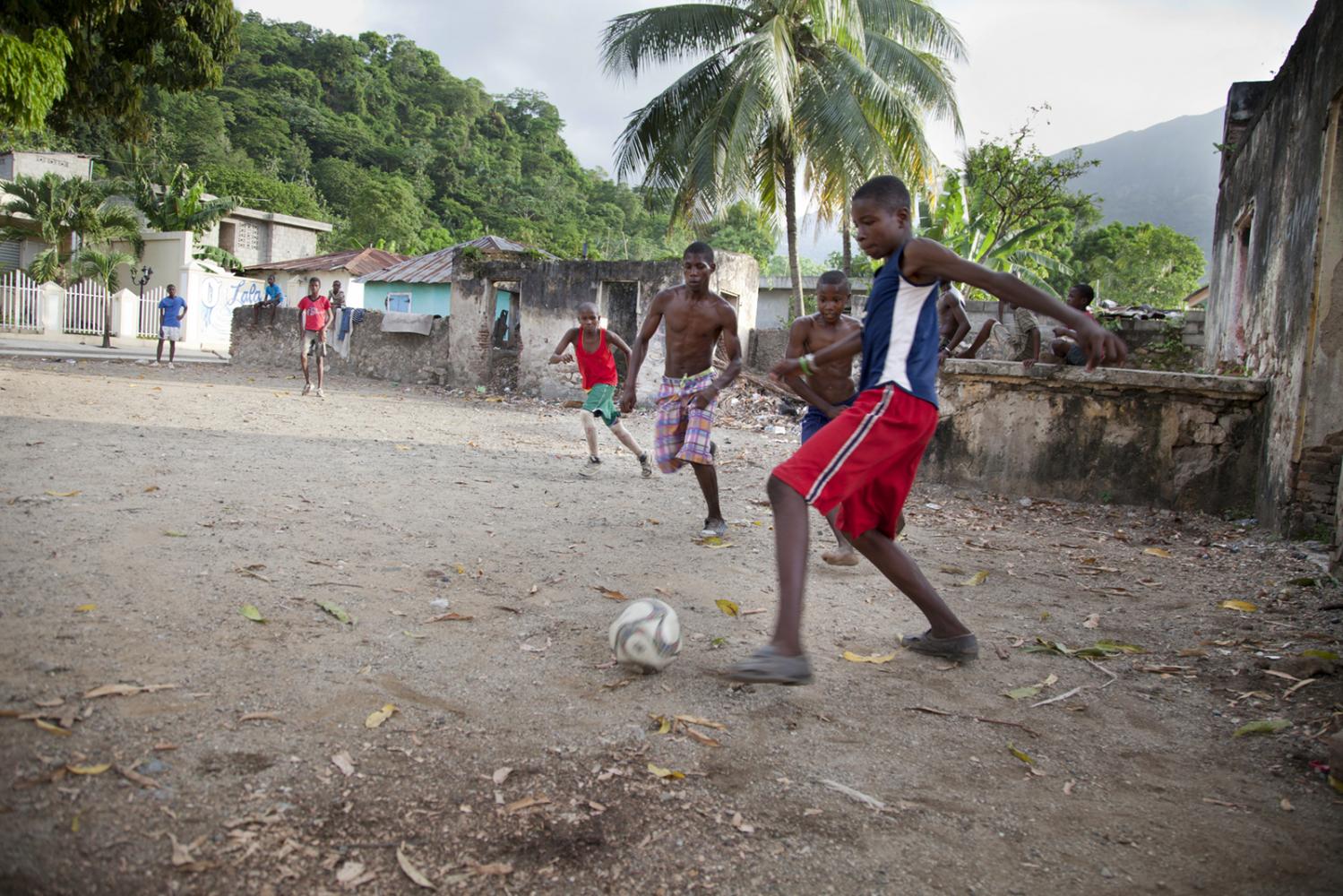 Boys play football in an empty lot in Milot, Haiti.