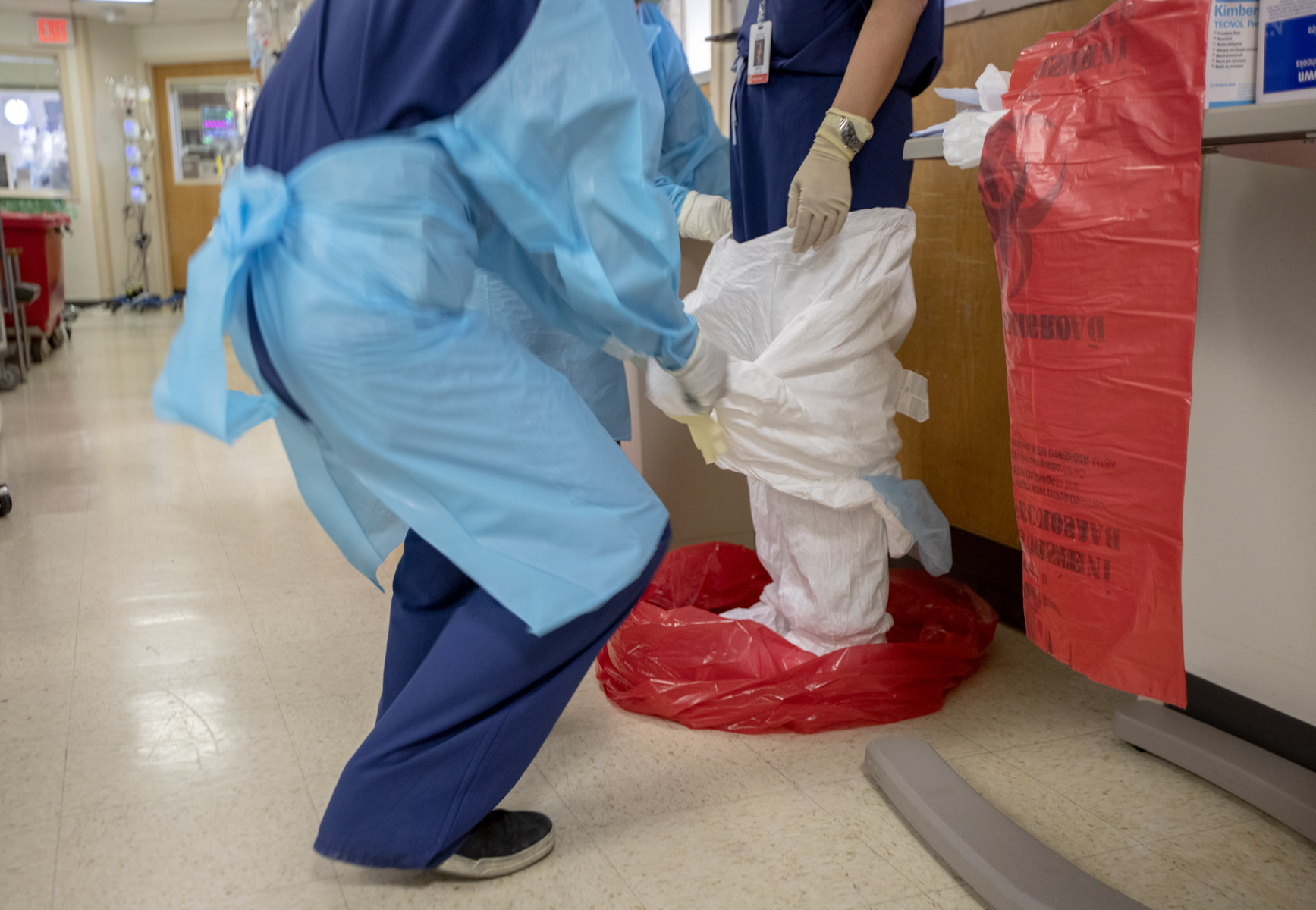 A Tyvek suit is removed carefully into a HAZMAT bag after exiting a COVID positive patient room in the ICU at Holy Name Medical Center.03/19/2020. Photo by Jeff Rhode/Holy Name Medical Center