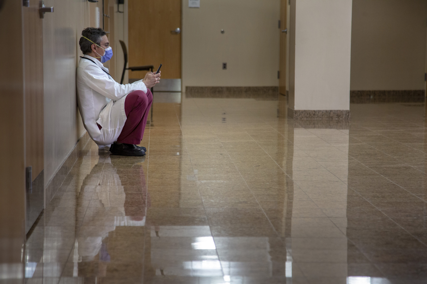A tired healthcare worker takes a break in a hallway at Holy Name Medical Center during the COVID-19 pandemic4/15 2020 Photo by Jeff Rhode.